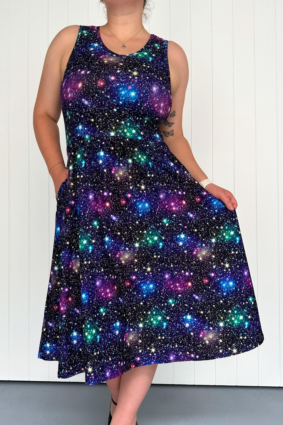 A sleeveless midi dress with a starlit multicolored pattern, featuring deep side pockets.
