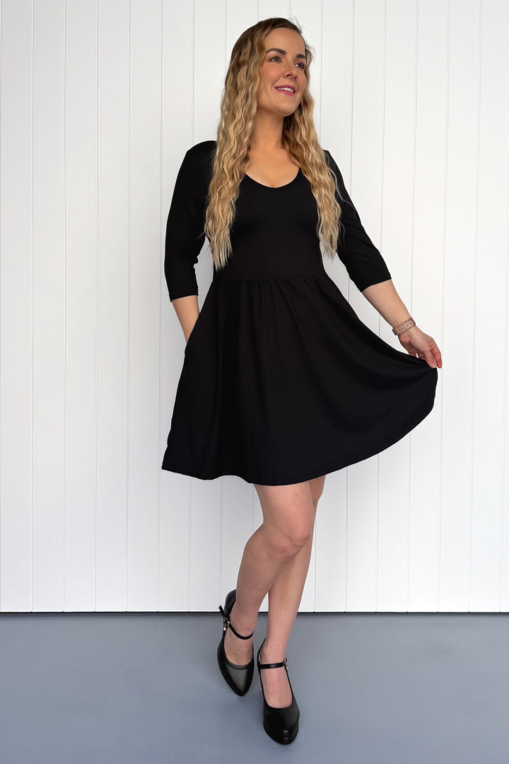 Woman wearing a black dress against a white background